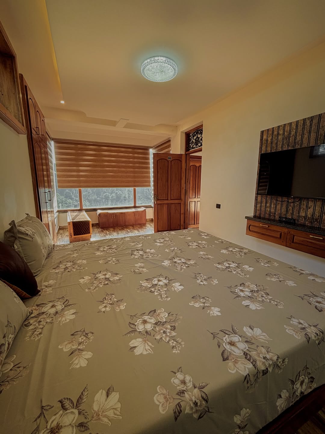Double room with white linen bed and wooden paneled wall